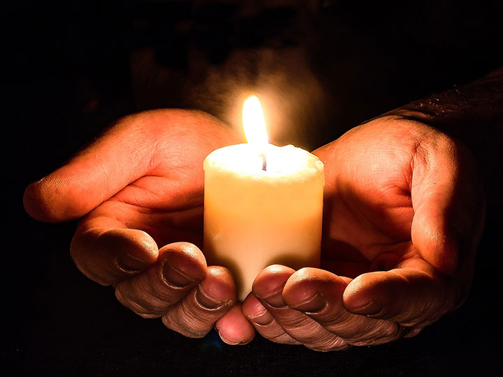 a hand holding a candle